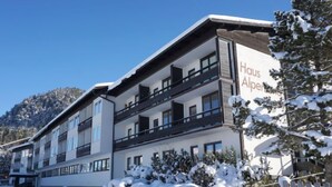 A multi-story hotel with balconies, snow-covered surroundings, and a mountainous backdrop. - Alpenland by Interhome (Seefeld in Tirol)