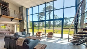 Un espacio habitable amplio con un gran ventanal, una escalera y un comedor.