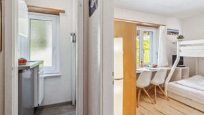 A compact room with a kitchenette, a bed, a desk, and a chair. - Promenade Apt 216 by Interhome (Arosa)