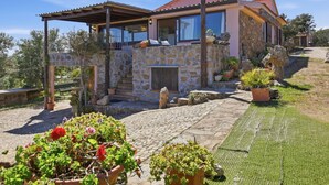 A stone house with a covered patio, stone steps, and potted plants. - Vacation home Iride by Interhome (Golfo Aranci)