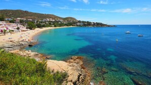 A coastal town with clear turquoise waters, a sandy beach, and buildings along the shore. - Santa Lucia by Interhome (Roses)