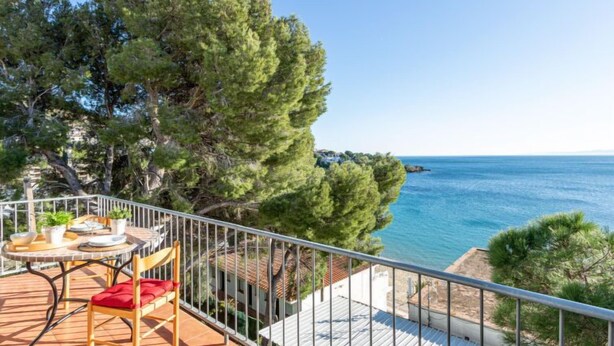 A balcony with a table and chairs overlooking a coastal view. - Santa Lucia by Interhome (Roses)