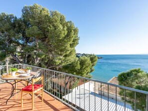 A balcony with a table and chairs overlooking a coastal view. - Santa Lucia by Interhome (Roses)