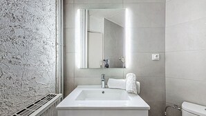 A bathroom with a white sink, a mirror, and a toilet. - Le Curling B (Val Claret) by Interhome (Tignes)