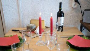 A dining table set with red napkins, clear wine glasses, and a candle. - Le Curling B (Val Claret) by Interhome (Tignes)