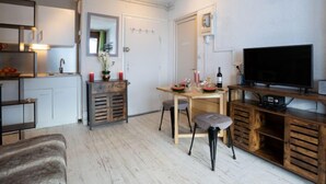 En kompakt bolig med et tekøkken, spiseplads og et fjernsyn.