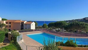 A swimming pool with a clear view of the sea and a hilly landscape in the background. - Le Petit Olivier by Interhome (Les Issambres)