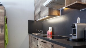 Une cuisine moderne avec des meubles en bois, un évier en acier inoxydable et une machine à café.