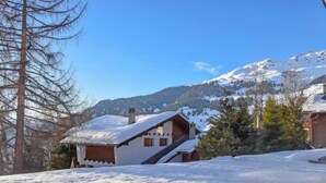 A snow-covered mountain landscape with a wooden cabin and a ski lift in the background. - Diure 0113 by Interhome (Verbier)