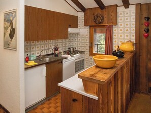 Een koelkast, een oven, een vaatwasser, kookgerei, borden en bestek