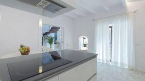 Uma cozinha moderna com bancada preta elegante, armários brancos e fogão embutido.
