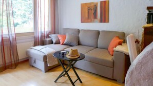Una sala de estar moderna con un sofá, una mesita y un cuadro en la pared.