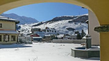 Un village enneigé, avec des bâtiments et une montagne en arrière-plan.