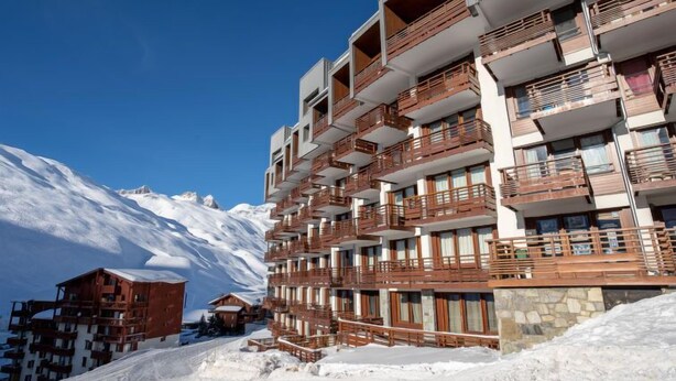 A multi-story hotel with balconies, set against a snowy mountain backdrop. - Le Curling B (Val Claret) by Interhome (Tignes)
