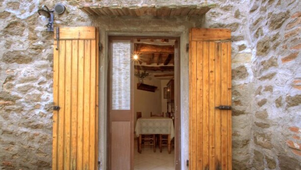 A stone building with a wooden door and a small table inside.