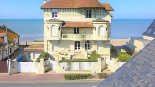 A two-story building with a balcony, located near a beach. - Kennedy by Interhome (Villers sur mer)