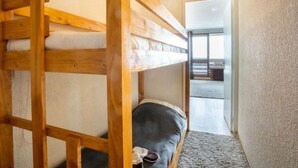 A bunk bed in a room with a view of a balcony and a door leading to another room. - Le Slalom (Val Claret) by Interhome (Tignes)