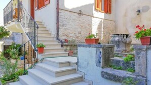 A set of outdoor stone steps leading up to a building with a white facade and red shutters. - Forlani by Interhome (Pula/Vodnjan)