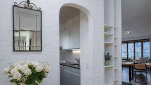Una cocina moderna con armarios blancos, un ventanal grande y un comedor con vistas al exterior.
