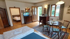 Une chambre à coucher avec un lit, un bureau et une table à manger avec des chaises.