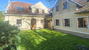 Une maison à deux étages avec une pelouse bien entretenue et un petit jardin.