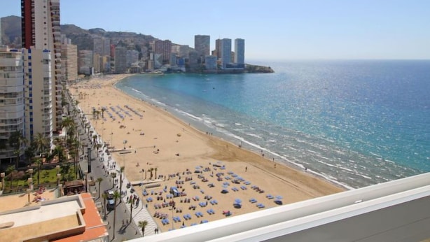 A coastal cityscape with a beach, high-rise buildings, and a clear sky. - Tor Serena by Interhome (Benidorm)
