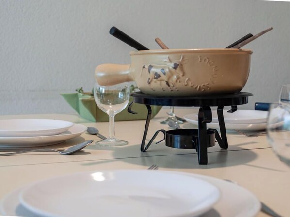 A table with a portable stove, a glass, and plates.