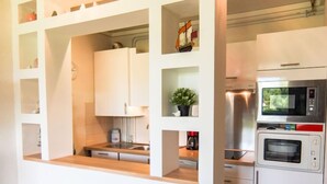 A compact kitchen with white cabinets, a microwave, an oven, and a sink. - Les Catalanes du Golf by Interhome (Saint Cyprien)
