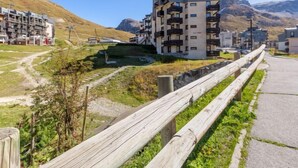 A modern apartment building with multiple balconies, situated in a hilly area with a clear sky. - Les Tufs (Val Claret) by Interhome (Tignes)
