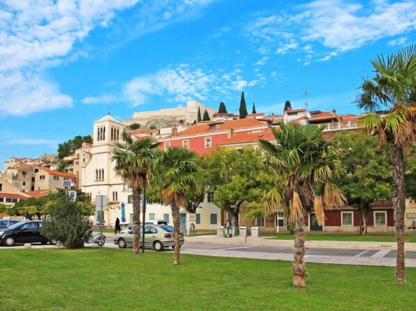 A historic town with a prominent church, palm trees, and a clear blue sky.