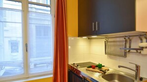 A compact kitchen with a window, a sink, and a cutting board with vegetables. - Bonsecours by Interhome (Deauville-Trouville)