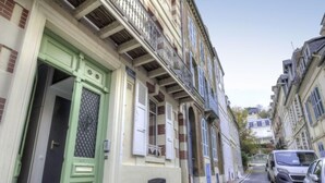 A narrow street lined with multi-story buildings, each with distinct architectural styles and balconies. - Bonsecours by Interhome (Deauville-Trouville)