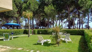 A well-maintained outdoor area with a lawn, several lounge chairs, and a small palm tree. - Cerrano by Interhome (Silvi Marina)