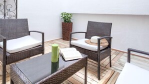 A small outdoor seating area with wicker furniture and a glass table. - Apartment  Ronda by Interhome (L'Escala)