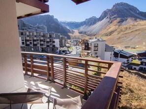 A balcony with a view of a mountain town, featuring modern buildings and a clear sky. - Le Curling B (Val Claret) by Interhome (Tignes)