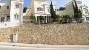 Una serie di edifici in stile mediterraneo, con pareti in pietra e balconi bianchi.