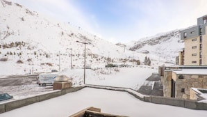 A snowy outdoor area with a building, a parked vehicle, and a snow-covered ground. - Le Grand Tichot A et B (Val Claret) by Interhome (Tignes)
