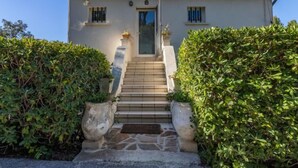 A two-story building with a tiled roof, a central entrance with a glass door, and a staircase leading to the entrance. - Carpe Diem by Interhome (Rayol Canadel)