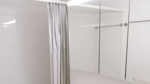 Et moderne badeværelse med toilet, håndvask og bruser.