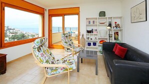 A living room with a balcony, a black sofa, a wooden coffee table, and a bookshelf. - Las Alondras by Interhome (Roses)