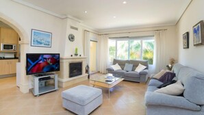 A modern living room with a television, sofa, ottoman, and fireplace. - Casa Kate by Interhome (Calpe/Calp)