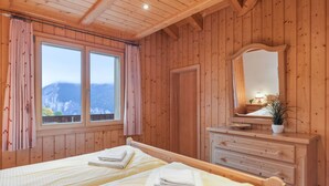 Een houten kamer met twee bedden, een kaptafel en een grote spiegel.