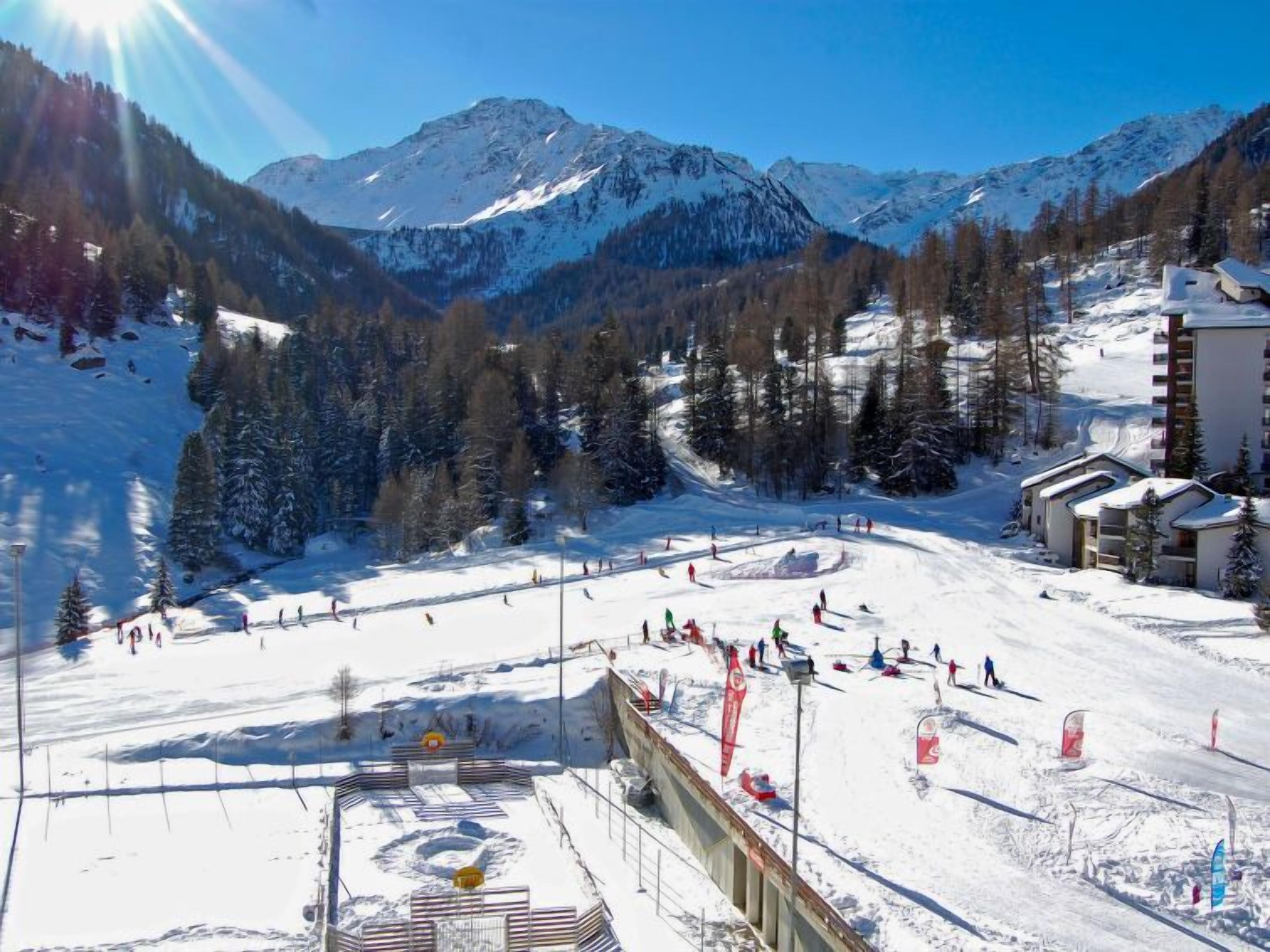 Une station de ski avec une piste enneigée, un télésiège et une vue sur les montagnes.