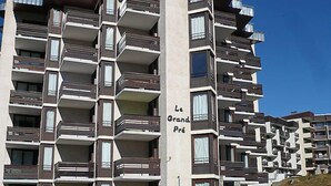 Un immeuble résidentiel à plusieurs étages, doté de balcons, portant l’inscription « Le Grand Prêt ».