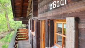 Una cabaña de madera con un letrero que dice "zGädi" y una terraza de madera que conduce a la entrada.