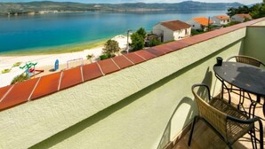 Un balcone con vista su una spiaggia e un mare calmo.