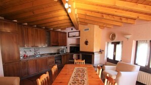 Una cocina acogedora con armarios de madera y un comedor con mesa y sillas de madera.