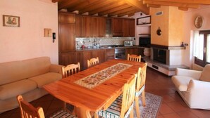 Una sala acogedora con una mesa de madera, un sofá y una chimenea.