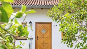 A wooden door with a geometric pattern, a number '23' above it, and a small step leading to the entrance. - Rheingau by Interhome (Dittishausen)