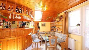 Interior de madera acogedor con zona de bar, asientos y una ventana.